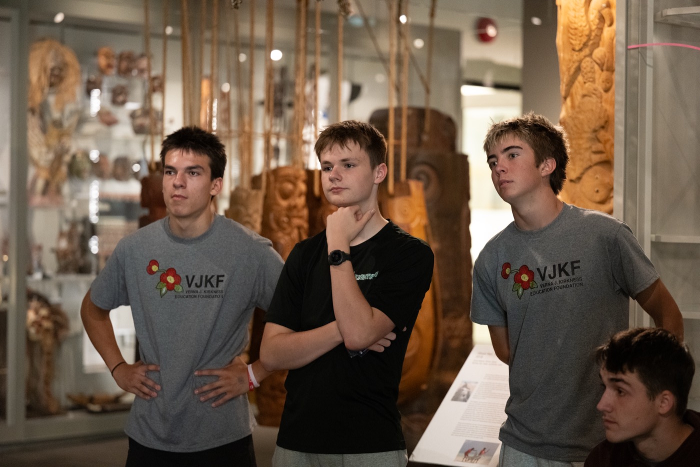 Kirkness Scholars in VJKF shirts viewing carvings in a campus museum