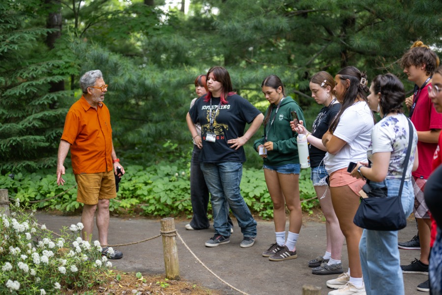A mentor leading Kirkness Scholars through a campus garden