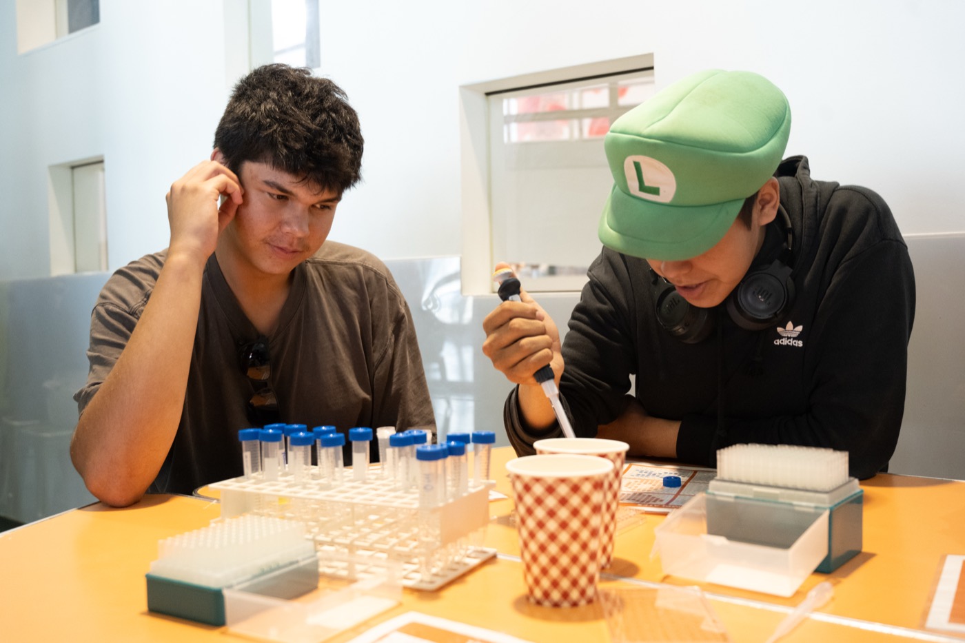 Two Kirkness Scholars using a pipette at a lab bench