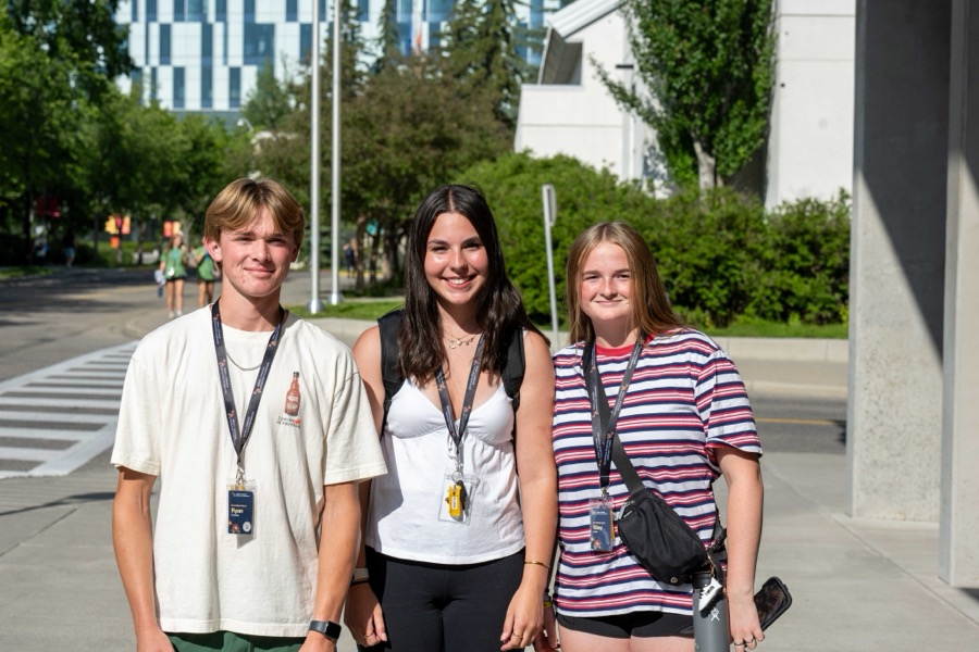 Three Kirkness Scholars walking across a university campus in summer