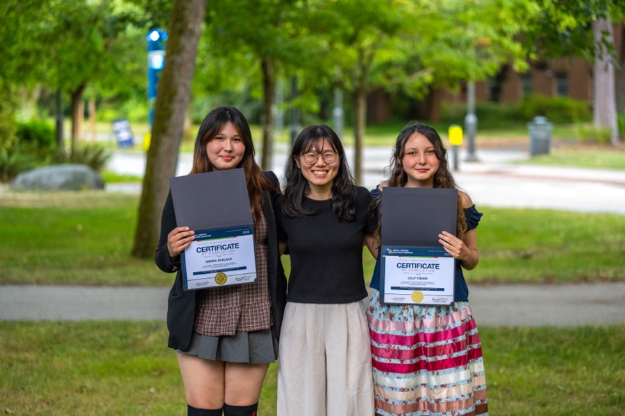Kirkness Scholars holding their program certificates with a mentor on campus