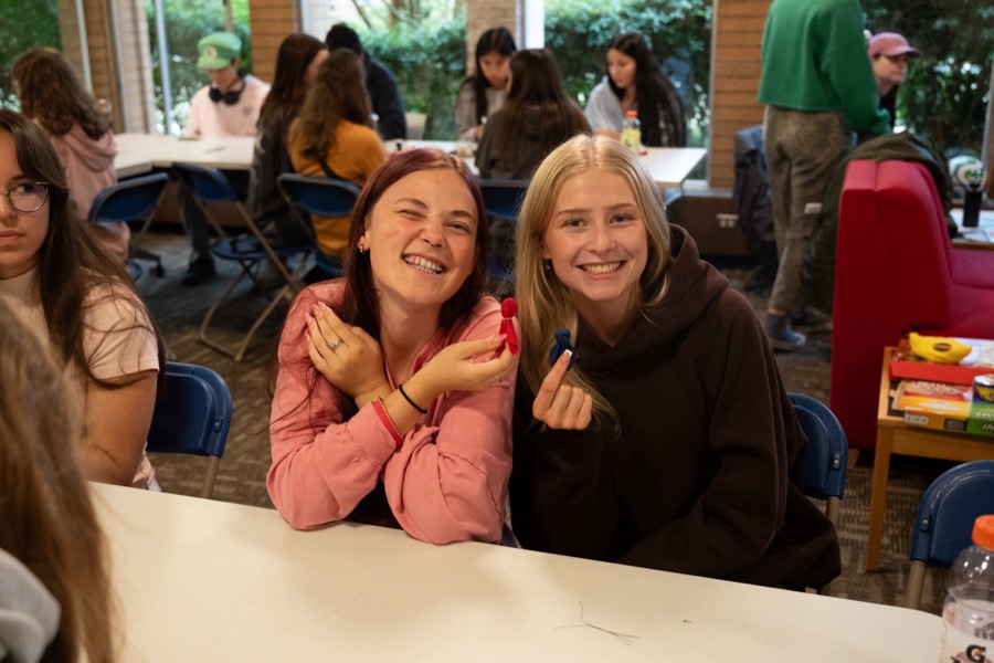 Two smiling Kirkness Scholars at a table during an evening group activity