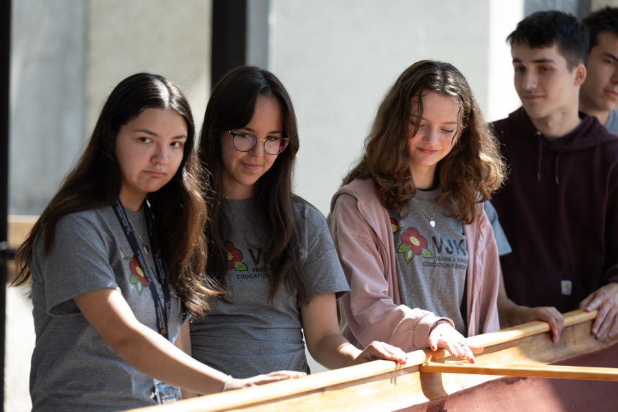 Kirkness Scholars in VJKF shirts working together on a long wooden frame