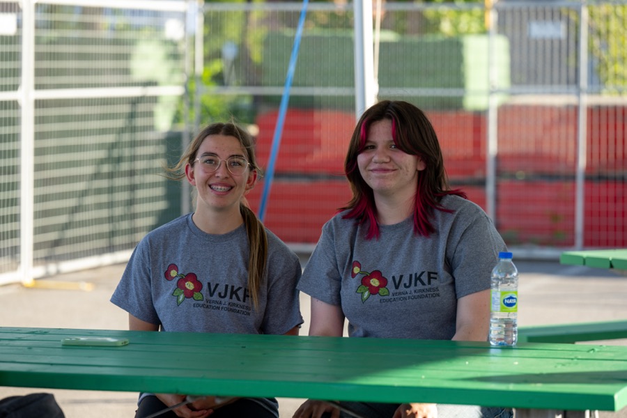 Two Kirkness Scholars in VJKF shirts sitting at a picnic table on campus